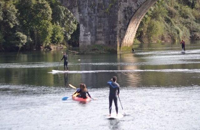 personas navegando en sup y en una piragua